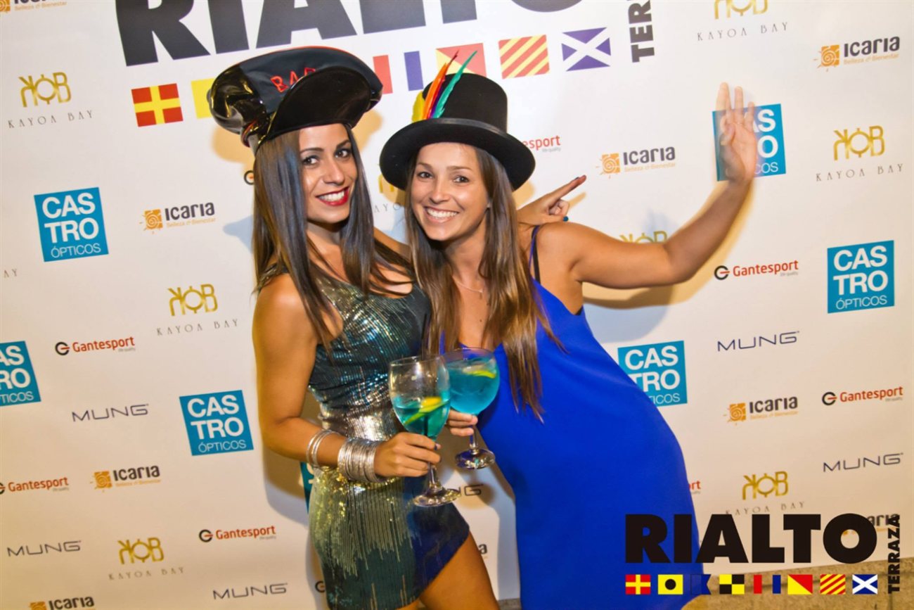 Dos amigas con sombreros y copas en el photocall de Rialto